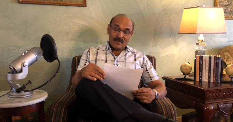 Khalid Rauf Qureshi writing at his desk